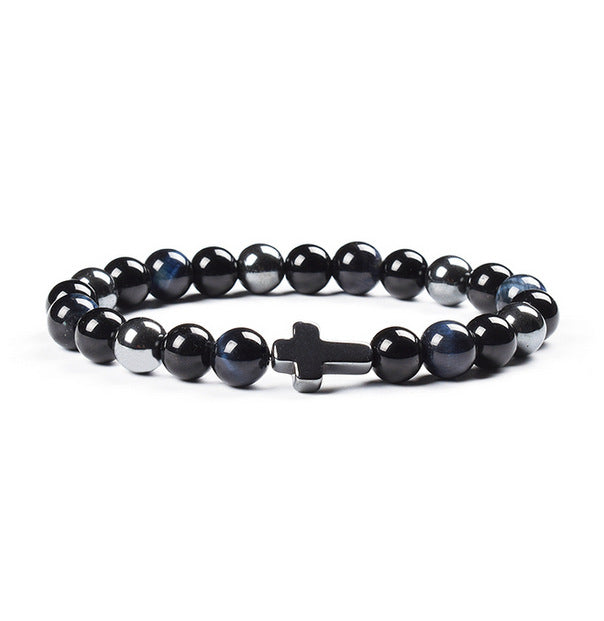 Black beaded bracelet with a silver cross charm on a white background
