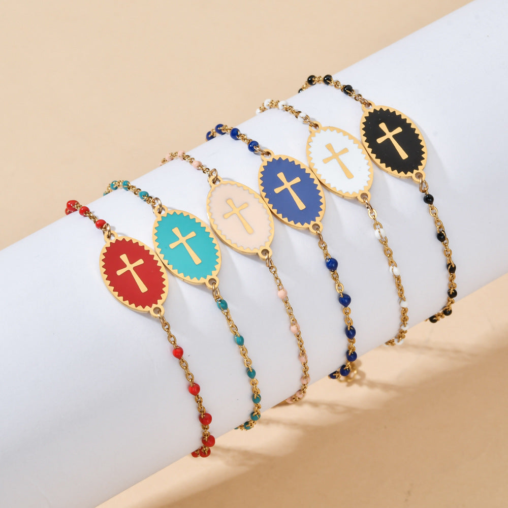 Set of colorful beaded bracelets with cross designs on a white surface.