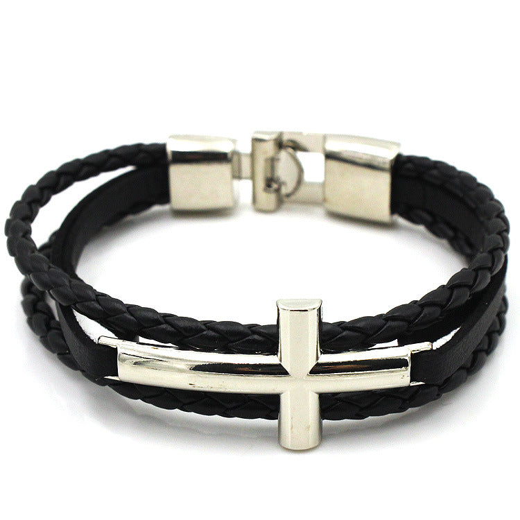 Black braided leather bracelet with silver cross charm on a white background