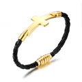 Black braided leather bracelet with gold cross and cylindrical beads on a white background