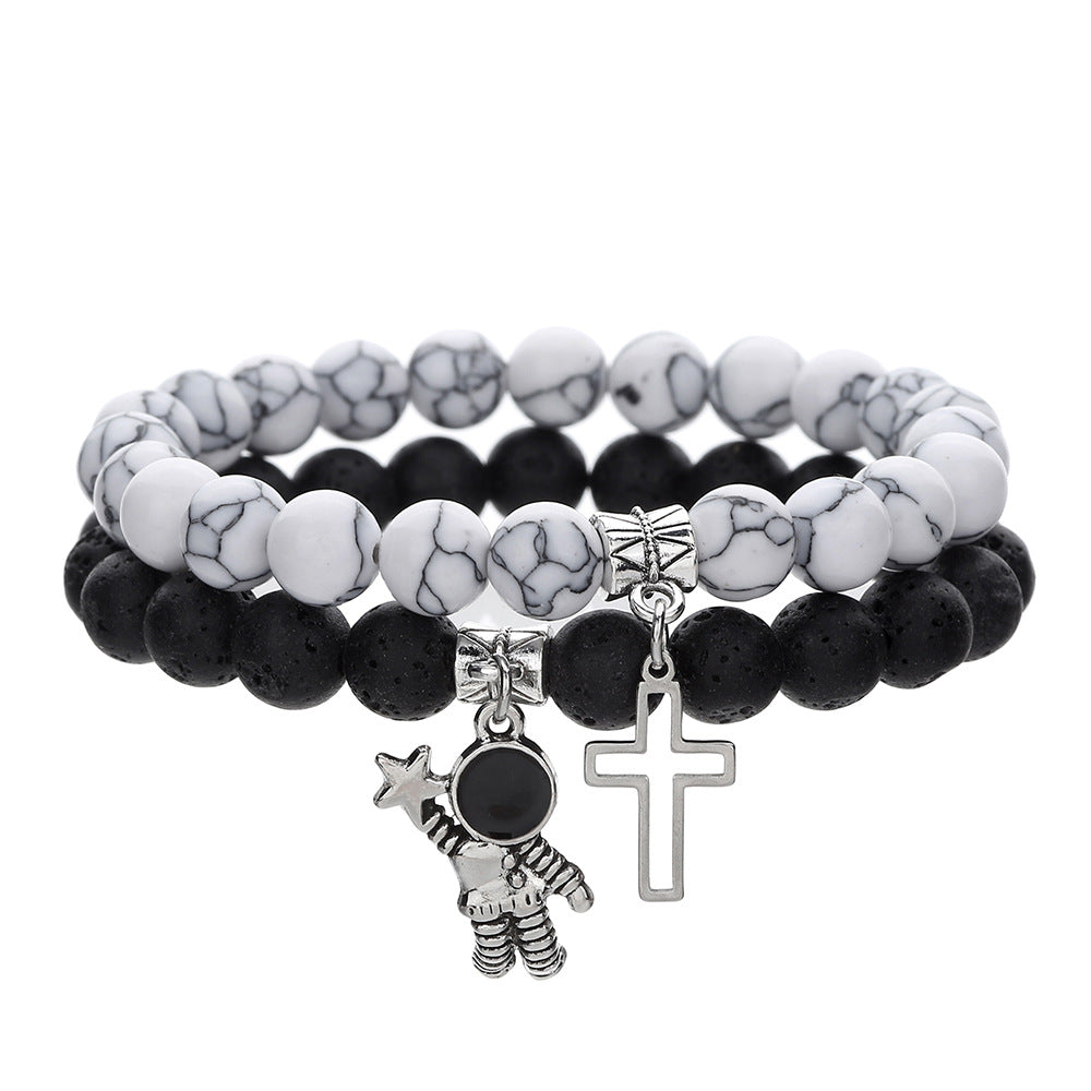 Stack of black and white beaded bracelets with charms on a white background