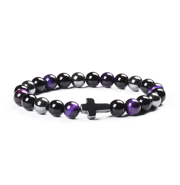 Beaded bracelet with a cross charm on a white background