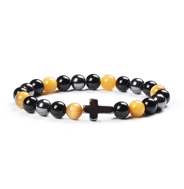 Beaded bracelet with a cross charm on a white background