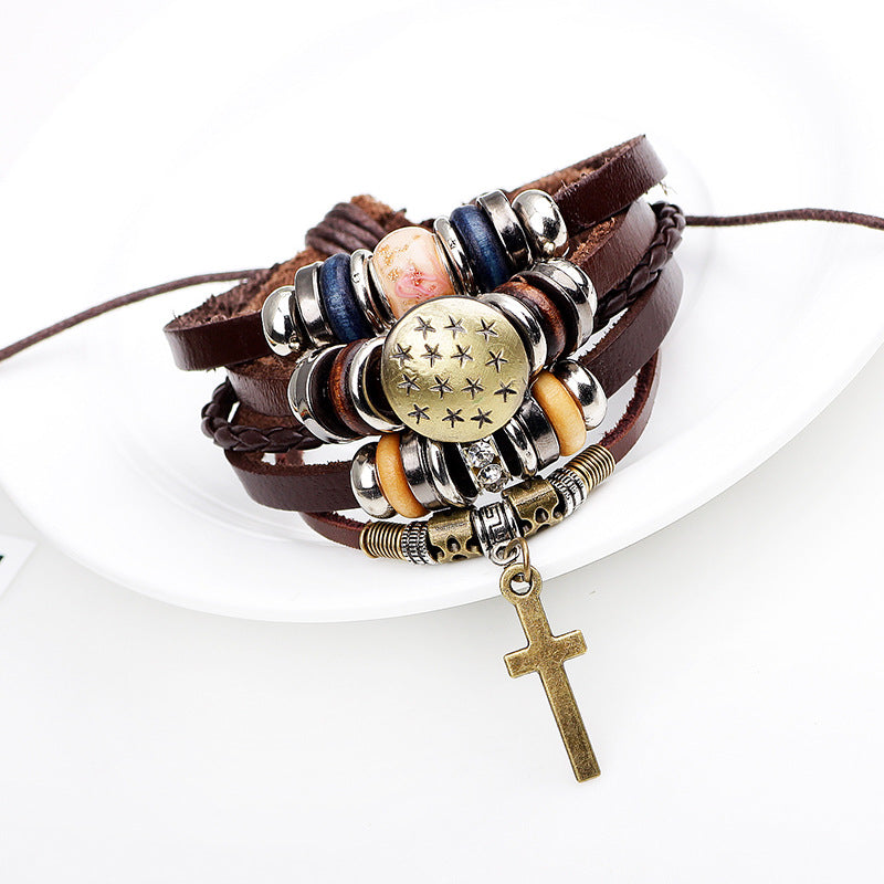 Multistrand leather bracelet with beads and a cross charm on a white background