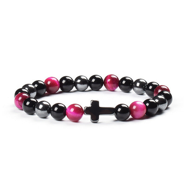 Beaded bracelet with black, pink, and gray beads and a cross charm on a white background