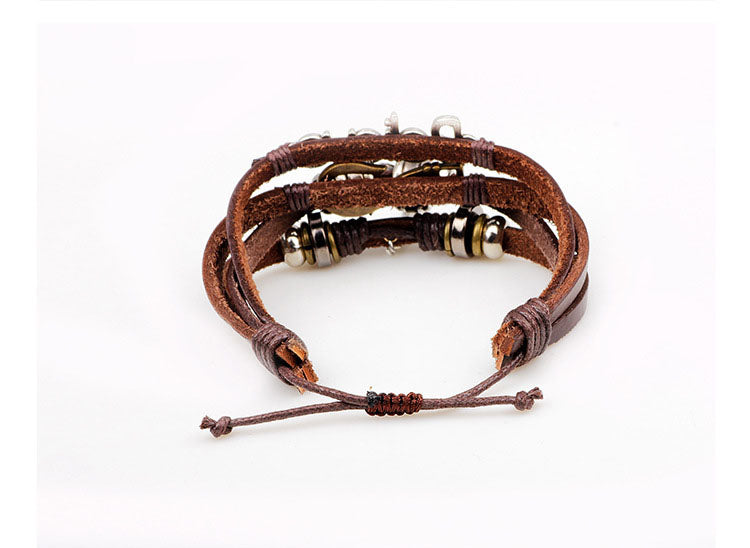 Brown leather bracelet with gold beads on a white background